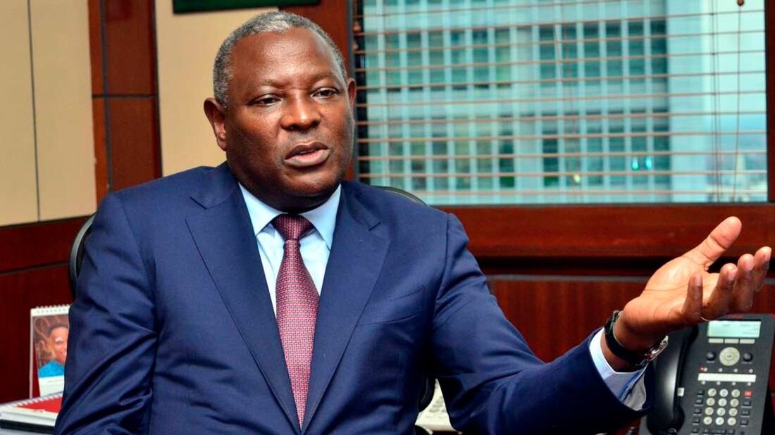 James Mwangi in a navy suit and red tie, seated in his office and gesturing with an open hand as he speaks